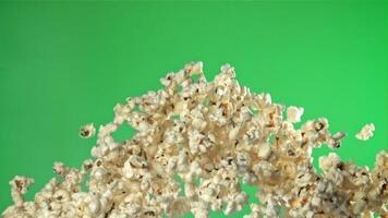 Popcorn flies up and falls down. On a green background. Filmed on a high-speed camera at 1000 fps. High quality FullHD footage video