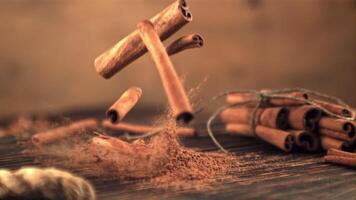 Super slow motion cinnamon sticks fall on the table . On a brown background. Filmed on a high-speed camera at 1000 fps. video