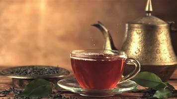 Super slow motion in a full cup with tea drops a drop. On a brown background. Filmed on a high-speed camera at 1000 fps. video