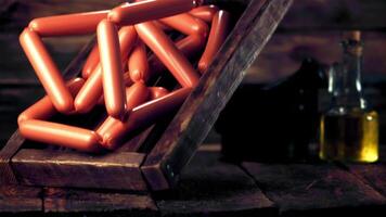 Super slow motion wooden tray with sausages falls on the table. On a wooden background. Filmed on a high-speed camera at 1000 fps. High quality FullHD footage video