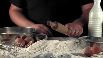 súper lento movimiento de los hombres manos cocinar horneando. en un negro antecedentes. filmado en un alta velocidad cámara a 1000 fps. video