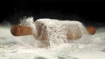 Super slow motion of the rolling pin falls on the table with flour. On a black background. Filmed on a high-speed camera at 1000 fps. video