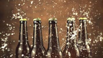 Super slow motion glass beer bottles with water splashes. On a brown background. Filmed on a high-speed camera at 1000 fps. video