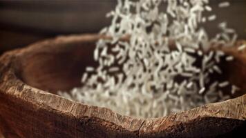 Rice is poured into a wooden bowl. Filmed on a high-speed camera at 1000 fps. High quality FullHD footage video