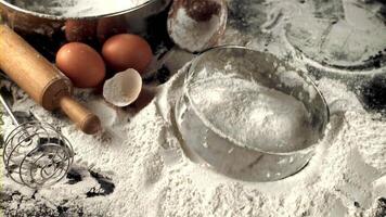 Super slow motion sieve falls on the table with flour and eggs. Macro background. Filmed on a high-speed camera at 1000 fps. video