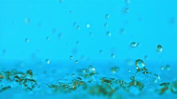 Super slow motion water droplets fall on a blue background. Filmed on a high-speed camera at 1000 fps.High quality FullHD footage video