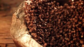 Buckwheat in a wooden bowl. Filmed on a high-speed camera at 1000 fps. High quality FullHD footage video