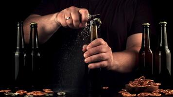 Super slow motion men's hands open the bottle with a beer opener. On a black background.Filmed on a high-speed camera at 1000 fps. video