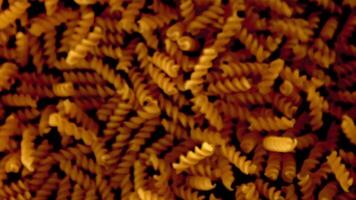 Super schleppend Bewegung Pasta Fusilli trocken. auf ein schwarz Hintergrund.gefilmt auf ein schnelle Geschwindigkeit Kamera beim 1000 fps. hoch Qualität fullhd Aufnahmen video