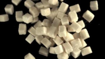 Super slow motion sugar cubes rise up and fall down. On a black background. Filmed on a high-speed camera at 1000 fps.High quality FullHD footage video