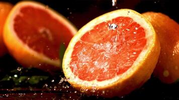 Super schleppend Bewegung auf ein Stück von frisch Grapefruit tropft Wasser. gegen ein dunkel Hintergrund. gefilmt beim 1000 fps. video