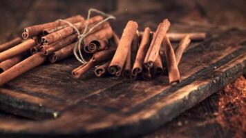 Super slow motion cinnamon sticks fall on the cutting board. On a wooden background.Filmed on a high-speed camera at 1000 fps. video