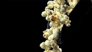 Popcorn caduta a partire dal un' notizia in anticipo su un' nero sfondo. girato su un' alta velocità telecamera a 1000 fps. alto qualità FullHD metraggio video