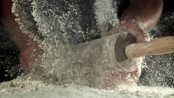 capocuoco con un' rotolamento perno nel il suo mani e volante Farina. girato su un' alta velocità telecamera a 1000 fps. alto qualità FullHD metraggio video