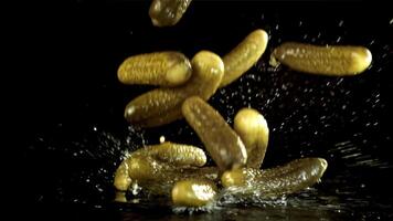 Pickled cucumbers fall with splashes. Filmed on a high-speed camera at 1000 fps. High quality FullHD footage video