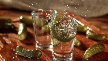 un en escabeche Pepino caídas dentro un vaso de vodka. filmado en un alta velocidad cámara a 1000 fps. alto calidad full HD imágenes video