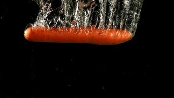 Carrot falls under water. Filmed is slow motion 1000 fps. High quality FullHD footage video