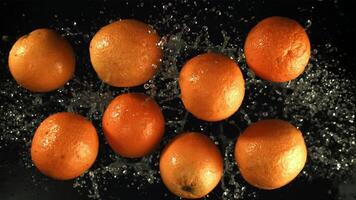 naranjas mosca arriba con agua gotas. filmado es lento movimiento 1000 fps. alto calidad full HD imágenes video