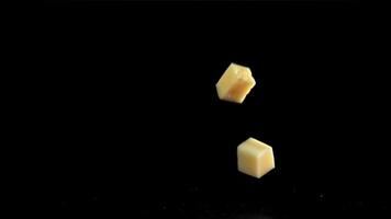 Super slow motion pieces of cheese on black background. Filmed on a high-speed camera at 1000 fps. High quality FullHD footage video