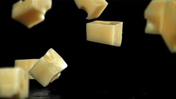 Super slow motion pieces of cheese on black background. Filmed on a high-speed camera at 1000 fps. High quality FullHD footage video