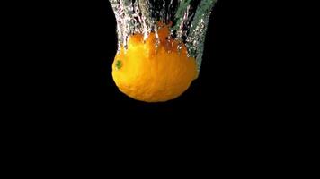 Super slow motion lemon falls under the water with air bubbles. On a black background. Filmed on a high-speed camera at 1000 fps. High quality FullHD footage video