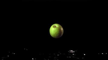 Super slow motion green fresh apples fall on the table. On a black background. Filmed on a high-speed camera at 1000 fps. High quality FullHD footage video