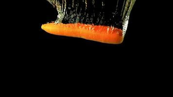 Super slow motion one fresh carrot falls under the water with air bubbles. On a black background.Filmed on a high-speed camera at 1000 fps. High quality FullHD footage video