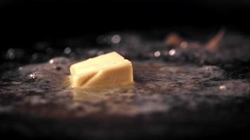 Super slow motion in the pan melts a piece of butter. On a black background. Filmed on a high-speed camera at 1000 fps. High quality FullHD footage video