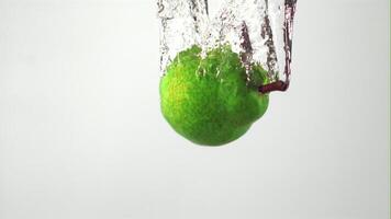 Super slow motion fresh pear falls under water. On a white background. Filmed on a high-speed camera at 1000 fps. High quality FullHD footage video