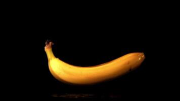 Super slow motion one banana falls on the table. On a black background. Filmed at 1000 fps. video