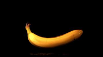 Super slow motion one banana falls on the table. On a black background. Filmed at 1000 fps. video