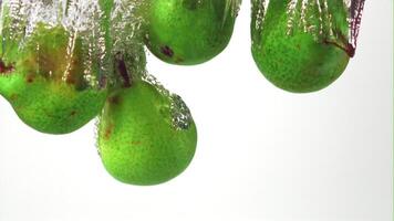 Super slow motion pears fall into the water with air bubbles. On a white background. Filmed on a high-speed camera at 1000 fps. High quality FullHD footage video