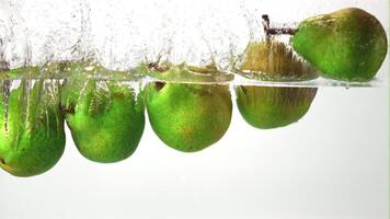 Super slow motion pears fall into the water with air bubbles. On a white background. Filmed on a high-speed camera at 1000 fps. High quality FullHD footage video