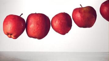 Super slow motion red apples fall into the water with splashes. On a white background.Filmed on a high-speed camera at 1000 fps. High quality FullHD footage video