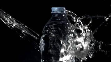 Super slow motion of the jet of water falls on the water bottle. Filmed on a high-speed camera at 1000 fps.On a black background. video