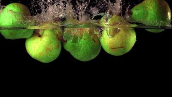 Super slow motion pears fall under the water with air bubbles. On a black background.Filmed on a high-speed camera at 1000 fps. High quality FullHD footage video