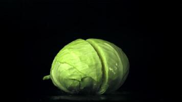 The super slow motion of the cabbage fork splits into half. On a black background. Filmed on a high-speed camera at 1000 fps. High quality FullHD footage video