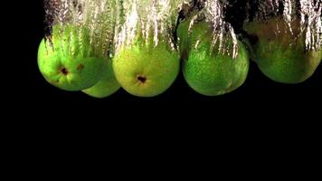 Super slow motion pears fall under the water with air bubbles. On a black background.Filmed on a high-speed camera at 1000 fps. High quality FullHD footage video