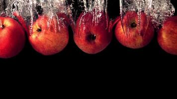 Super slow motion juicy apples fall under the water with air bubbles. On a black background.Filmed on a high-speed camera at 1000 fps. High quality FullHD footage video