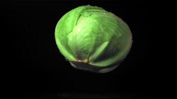 Super slow motion forks cabbage falls on the table with splashes of water. Filmed on a high-speed camera at 1000 fps.On a black background. video