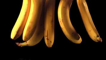 Super slow motion ripe bananas fall into the water with splashes. On a black background.Filmed on a high-speed camera at 1000 fps. video