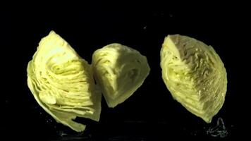 Super slow motion the cabbage pieces fall into the ode with the spray. On a black background. Filmed at 1000 fps. video