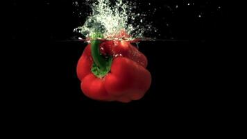 Super slow motion pepper falls under the water with splashes and air bubbles. Filmed at 1000 fps.On a black background. video