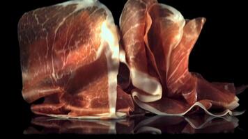 Super slow motion pieces of fragrant Spanish ham fall.Filmed at 1000 fps. On a black background. video