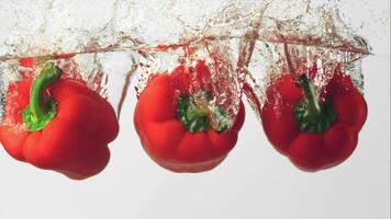 super langzaam beweging rood peper valt onder de water met spatten. Aan een wit achtergrond. gefilmd Aan een hoge snelheid camera Bij 1000 fps. video