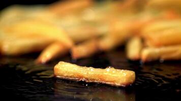 super lento movimento francese patatine fritte siamo fritte nel olio nel un' frittura padella. girato su un' alta velocità telecamera a 1000 fps.on un' nero sfondo. video