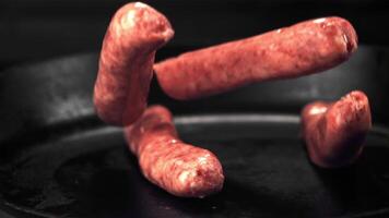 Super slow motion raw sausages fall on the pan. On a black background.Filmed on a high-speed camera at 1000 fps. video