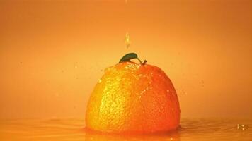 Super slow motion on a ripe orange drops a drop of juice. On an orange background. Filmed on a high-speed camera at 1000 fps. video