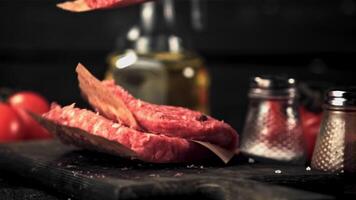 The super slow motion of the raw burger falls on the cutting board. Filmed on a high-speed camera at 1000 fps.On a black background. High quality FullHD footage video