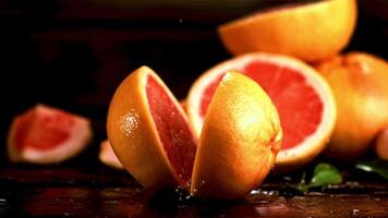 super langzaam beweging grapefruit valt Aan de tafel en splitst in twee helften. gefilmd Bij 1000 fps.aan een zwart achtergrond. video